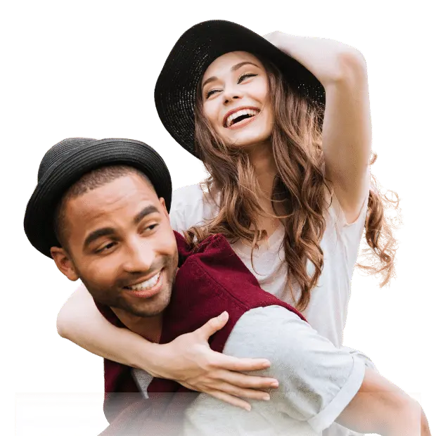 A happy couple with hats smiling and posing for Loveland Dental in Asheboro, NC with white teeth.